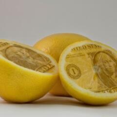 Lemons cut in half and the insides are the face of a dollar bill
