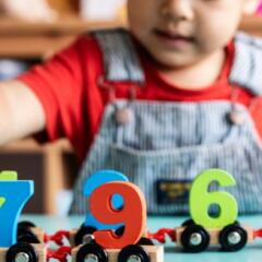 Little boy playing mathematics wooden toy at nursery