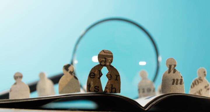 Row of silhouette of people standing in front of a magnifier