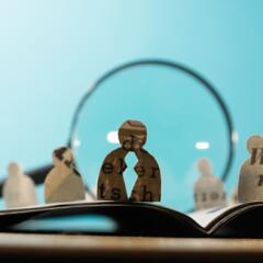 People cut out of newspaper behind Magnifier 