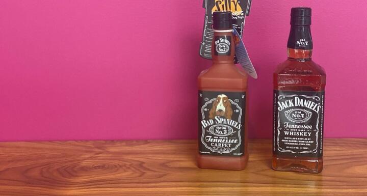 A bottle of Jack Daniels beside dog toy Bad Spaniel's