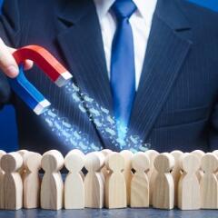 A man collects money with a magnet from wooden toy people