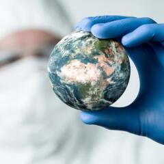 Main in lab coat inspecting world