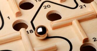 Maze game with a marble and holes in a game board