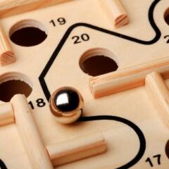 Maze game with a marble and holes in a game board