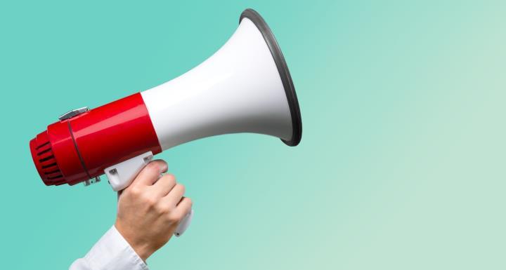 Hand holding red and white megaphone