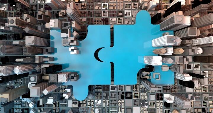 Giant blue puzzle pieces coming together in a city block