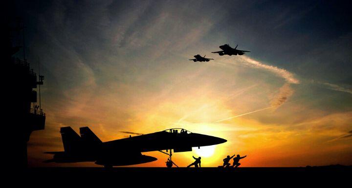 Military aircraft before take-off from aircraft carrier on sunset background