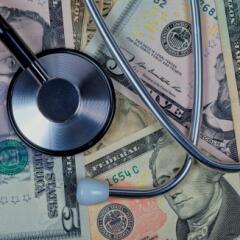 Stethoscope lying on top of paper money