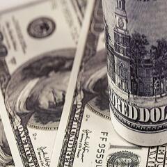 A stack of rolled up hundred dollars bills on top money