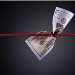 Paper money with red rope tied around the middle