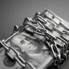 Stack of 100 bills wrapped in a silver chain