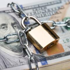 stack of money in chains with padlock