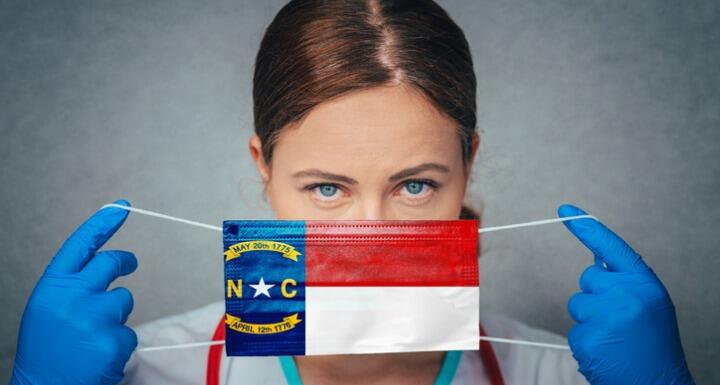Woman Medical Professional putting on NC Flag Mask