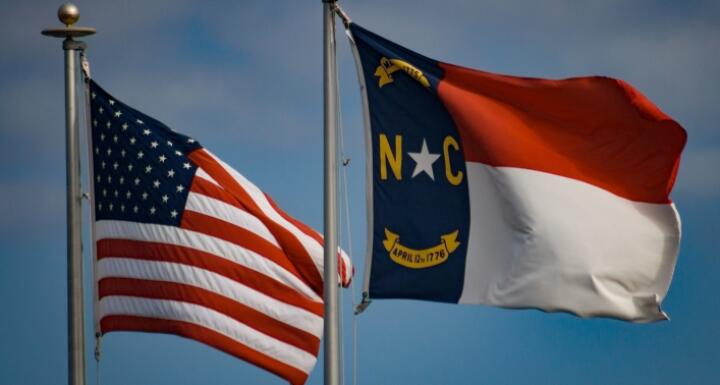 American and North Carolina flags waving in the wind