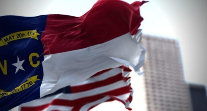 North Carolina state and American flag waving in the wind