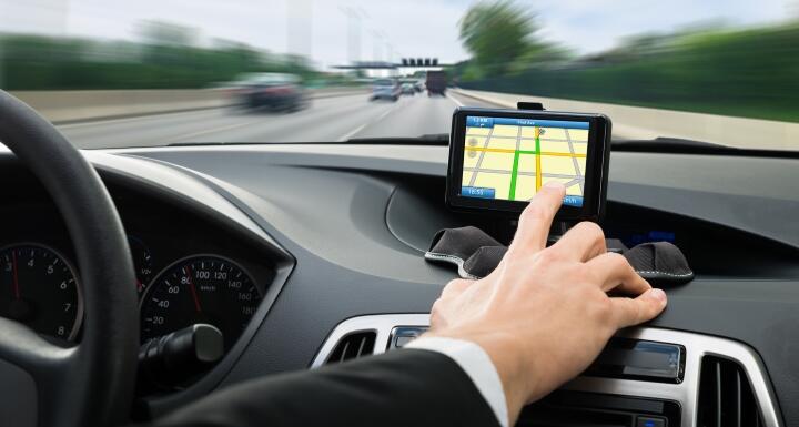 Man driving car while touching gps navigation screen