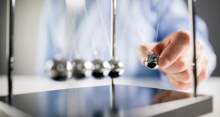 Man holding a ball of a Newton's Cradle