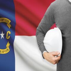 North Carolina Flag with man holding white hard hat