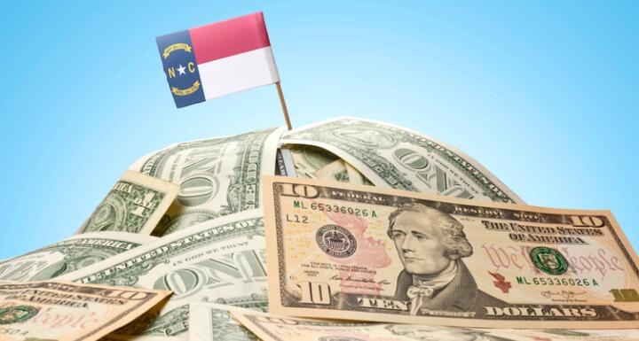 North Carolina Flag sticking in a pile of money