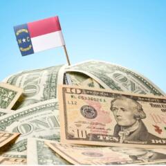North Carolina Flag sticking in a pile of money