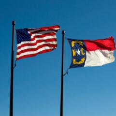 North Carolina State Flag and US Flag blowing in the wind 