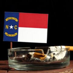 North Carolina flag with burning cigarette in ashtray