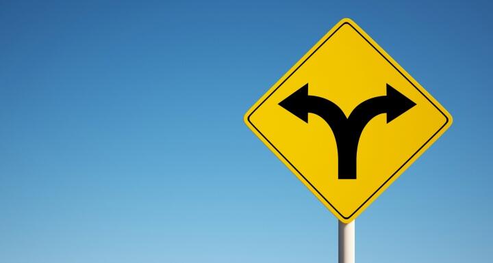 Road sign with arrows pointing in opposite directions