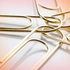 FIVE GOLD PAPER CLIPS CONNECTED IN A CIRCLE