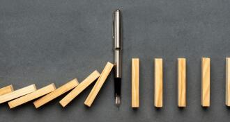 Pen stopping dominoes from falling