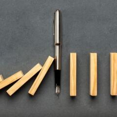 Pen stopping dominoes from falling