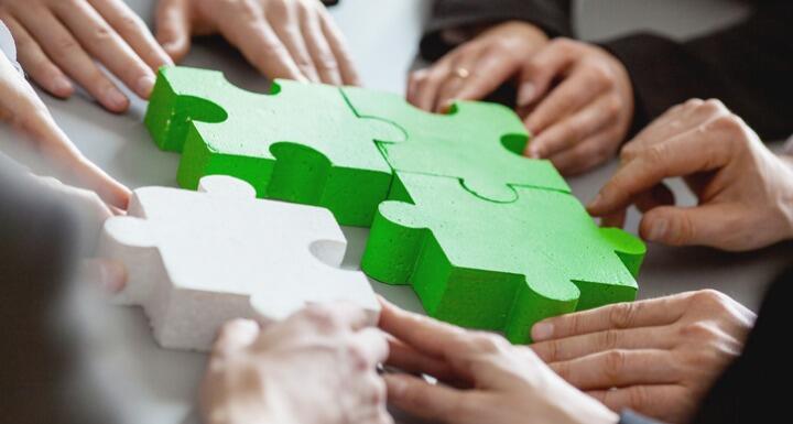 Business people assembling green and white puzzle