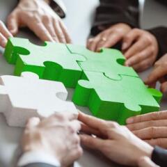 Business people assembling green and white puzzle