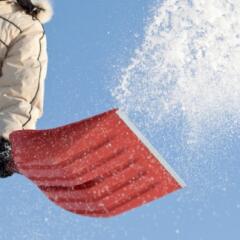 Person using a red shovel to shovel snow