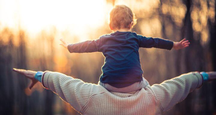 A grandson sitting on his grandfather's shoulders