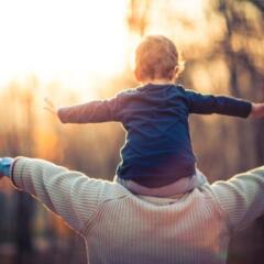 A grandson sitting on his grandfather's shoulders