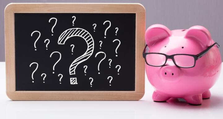 piggy bank with glasses and blackboard with question marks