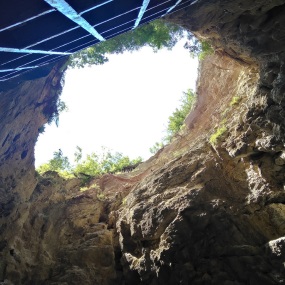 Cave or hole in the ground with sky in the background