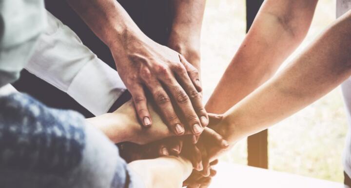 Multiple people putting hands into a circle