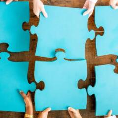 Six blue puzzle pieces on wooden table