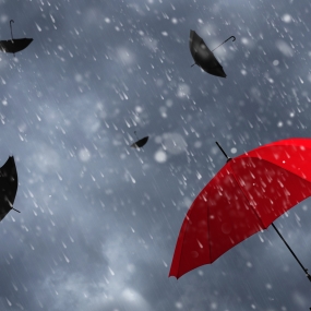 A red umbrella with black umbrellas and rainy skies