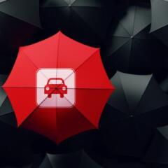 Red umbrella surrounded by black umbrellas, 