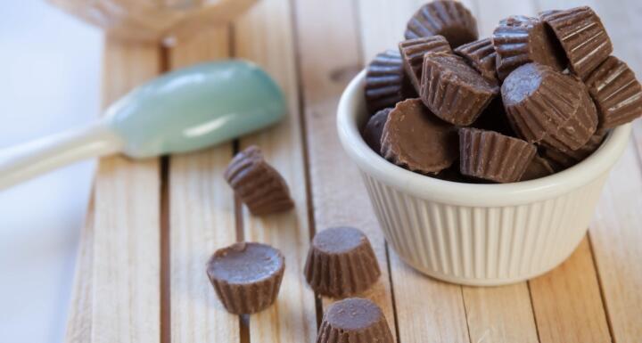 White bowl of Mini Reese Peanut Butter Cups overflowing