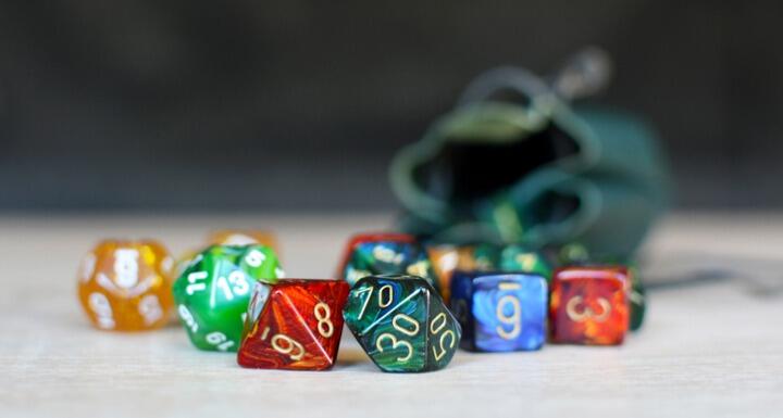 Colorful dice from various games spilled onto a table top