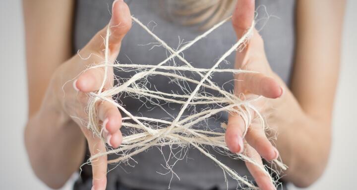 Woman unraveling a cat's cradle