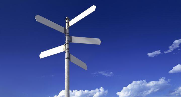 Signpost with three blank signs on sky backgrounds