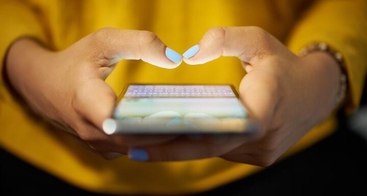 A woman holding a cell phone in her hands