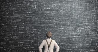Man facing large chalkboard covered in math equations