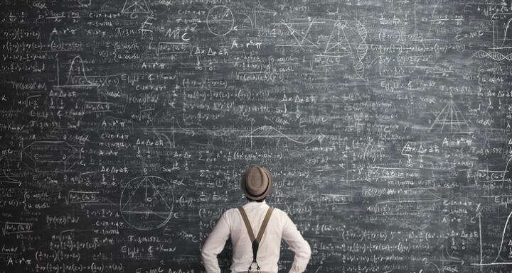 Man solving math problem on blackboard