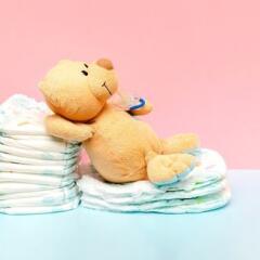 Stack of diapers with cute teddy bear